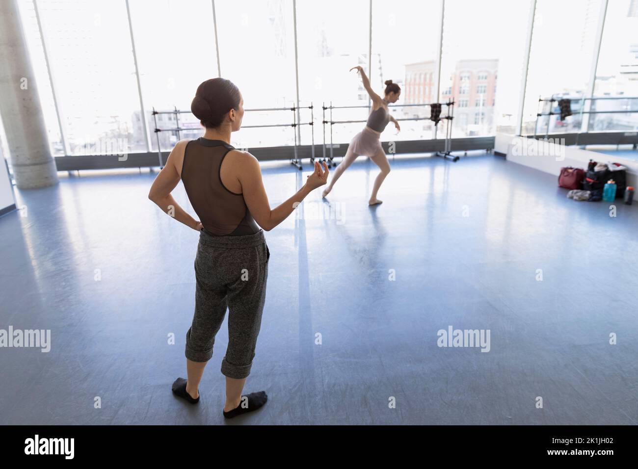 Female dance instructor guiding ballerina in dance studio Stock Photo