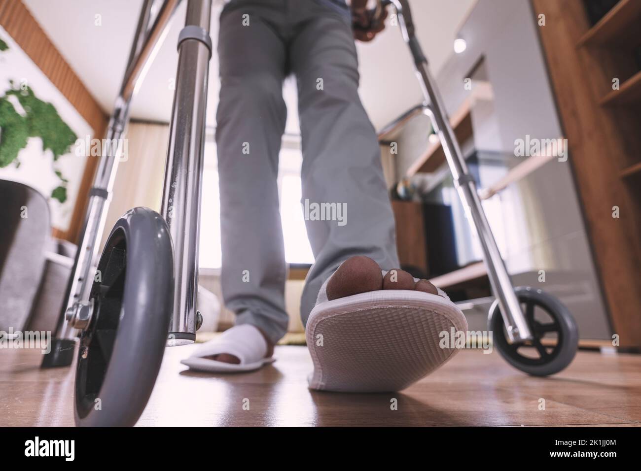 a sick person walks with the help of special devices for rehabilitation. Walkers for adults. rehabilitation after a broken leg or stroke. Stock Photo
