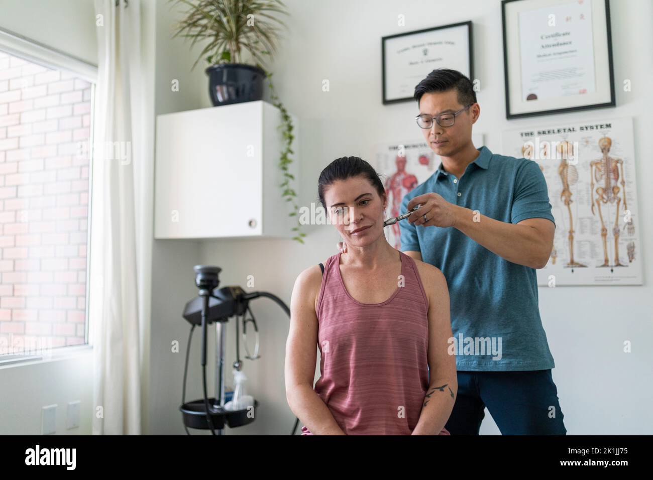 Natural medicine practitioner treating client with neck pain Stock