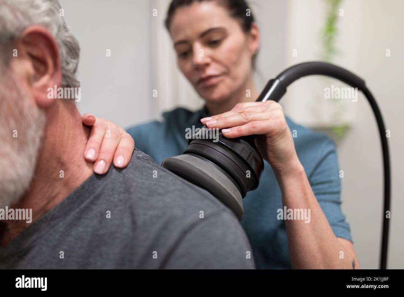 Natural medicine practitioner treating client with shoulder pain Stock