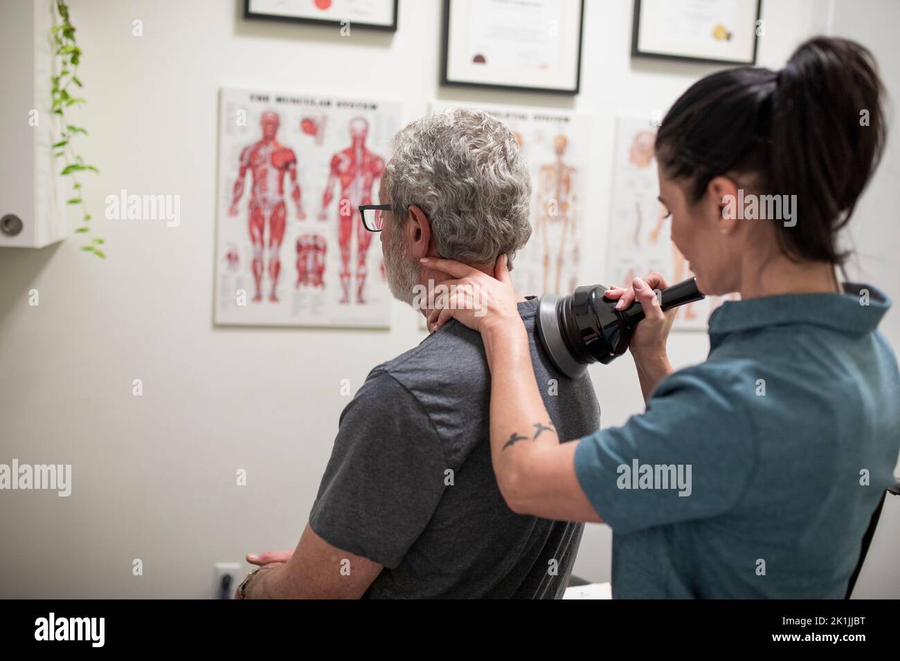Natural medicine practitioner treating client with shoulder pain Stock