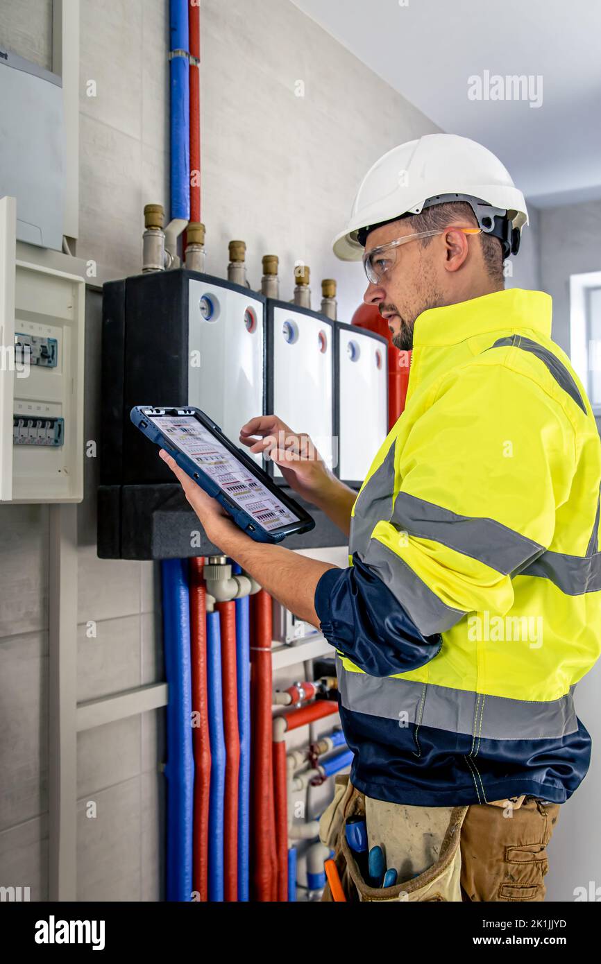 Electrical technician looking focused while working in a switchboard with fuses. Stock Photo