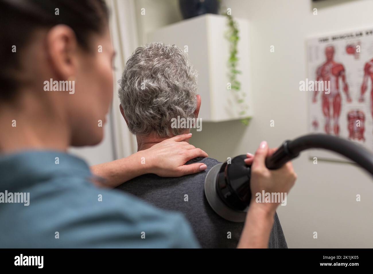 Natural medicine practitioner treating client with shoulder pain Stock
