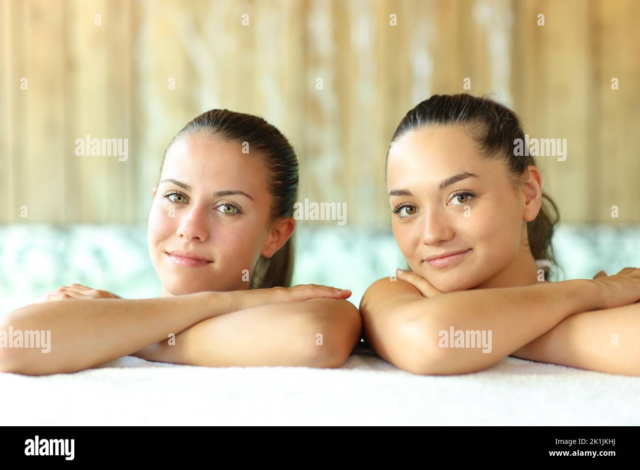 Two beautiful women posing looking at camera in a spa pool Stock Photo