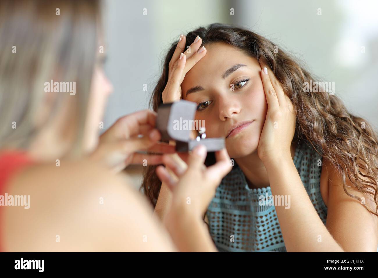 Worried lesbian woman in a marriage proposal rejecting engagement Stock Photo