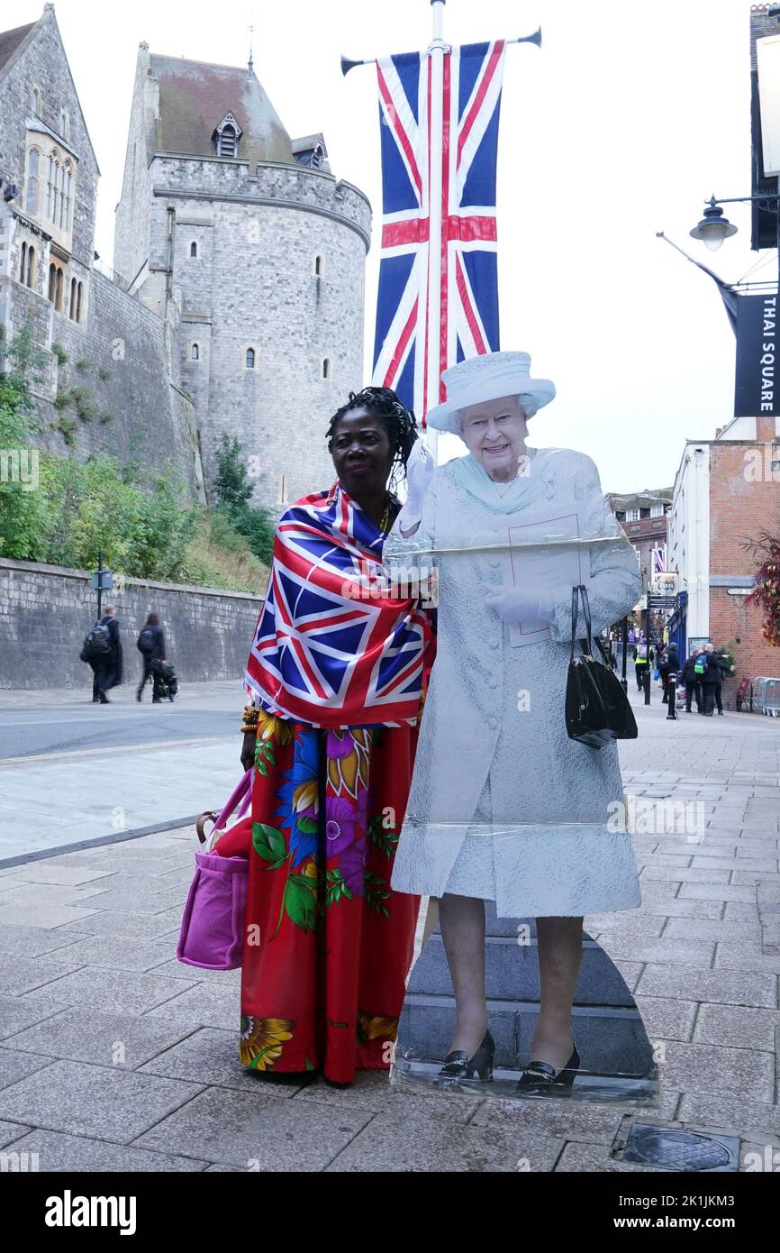 A member of the public standing next to a cardboard cut out of Queen Elizabeth II in Windsor, Berkshire ahead of Queen Elizabeth II state funeral on Monday. Picture date: Monday September 19, 2022. Stock Photo