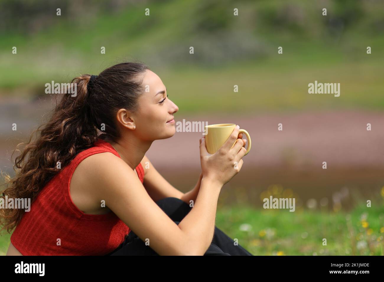 Profile of a woman drinking coffee in the mountain looking away Stock Photo