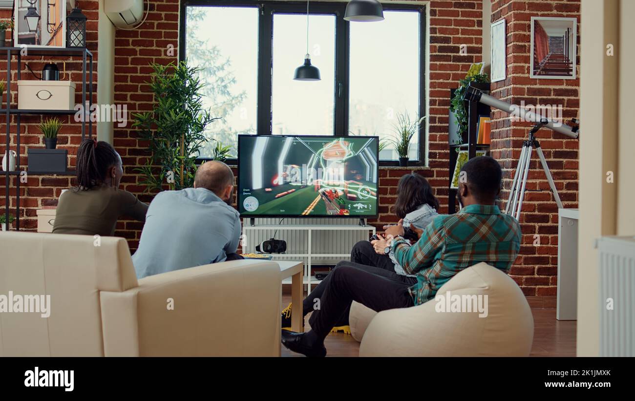 Diverse people having fun with video games online on tv console ...