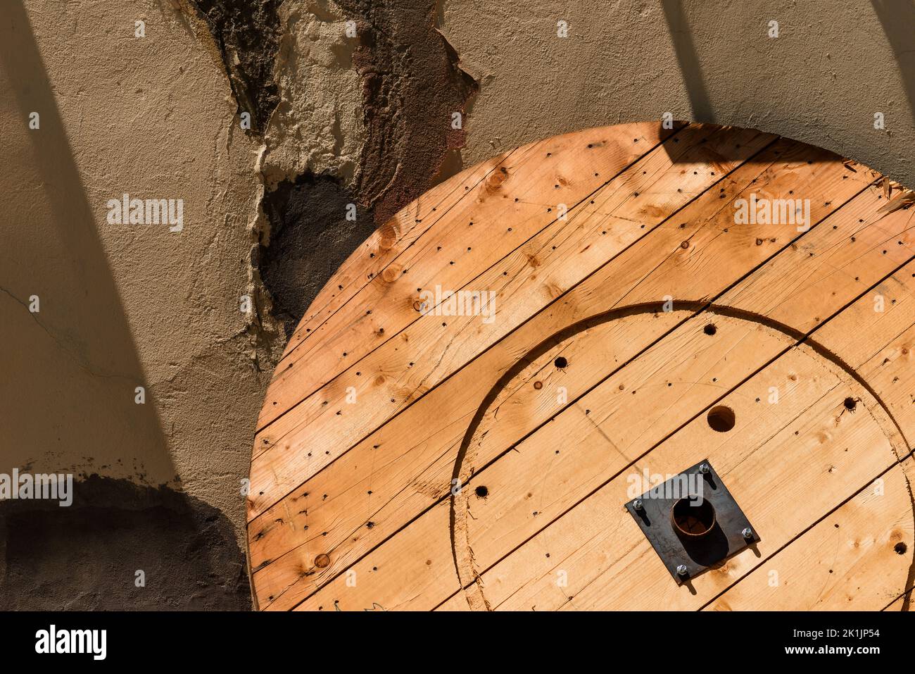 Part of wooden cable reel leaning on to abandoned industrial building in bad condition, copy space Stock Photo