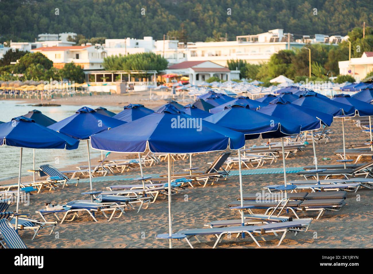 Beach with parasols and sunloungers in Faliraki, Rhodes, Greece. Stock Photo