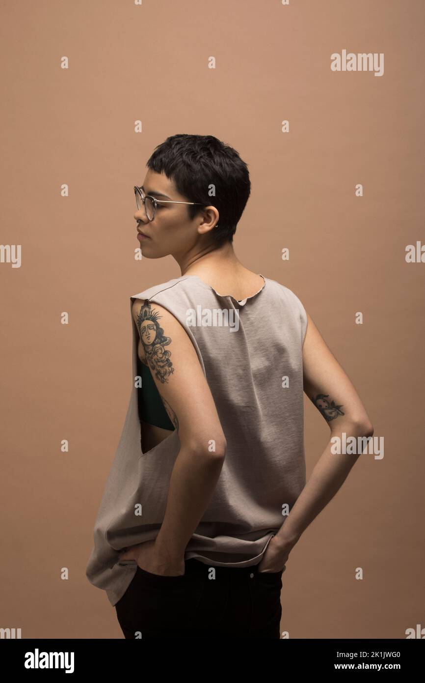 Portrait of nonbinary man with tattoos in tank top Stock Photo