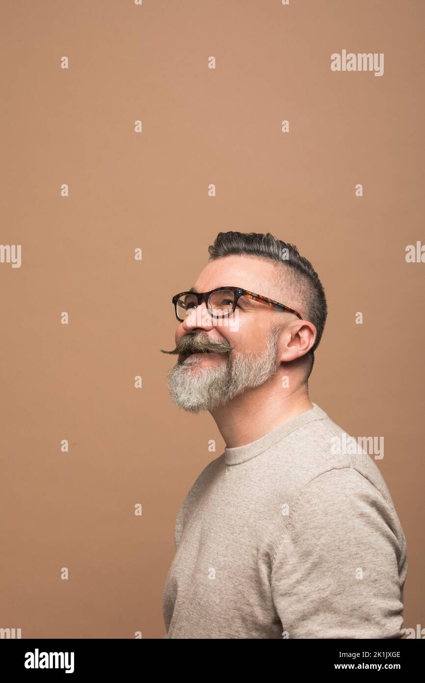 Portrait of hopeful man with mustache and beard looking up Stock Photo