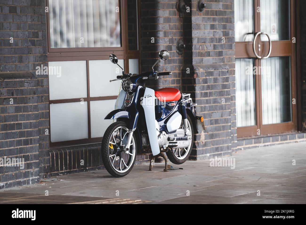 A moped against a brick wall outdoors in Ipswich, England Stock Photo