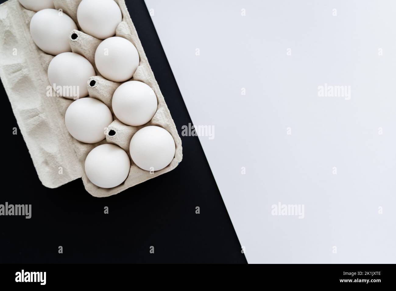 Top view of natural chicken eggs in carton tray on white and black ...