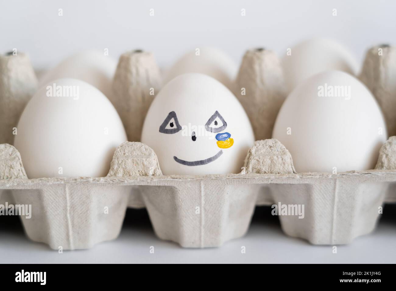 Painted egg with facial expression and ukrainian flag on white background Stock Photo
