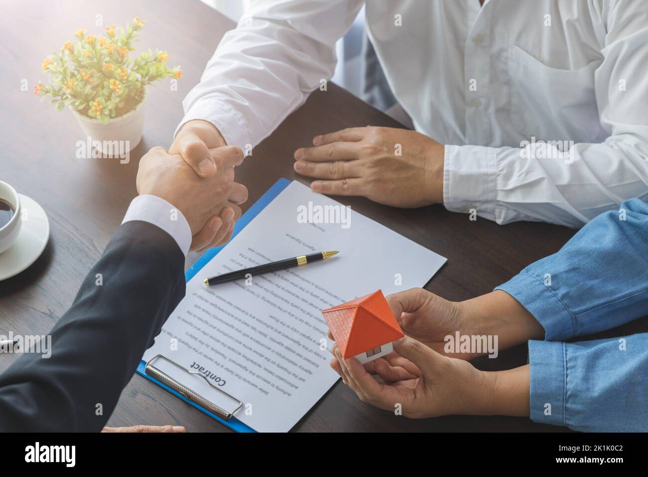 Real estate agents and customers shake hands to congratulate after