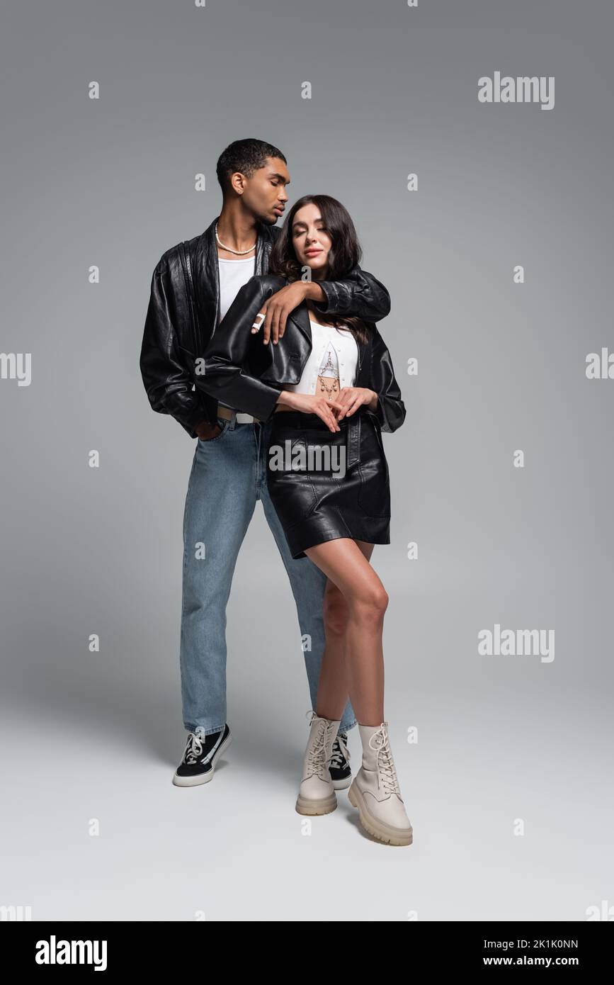 Outdoor full body portrait of young beautiful fashionable couple posing in  street. Models wearing stylish denim clothes, trendy sunglasses. Red  background. Fashion concept. City lifestyle Stock Photo | Adobe Stock