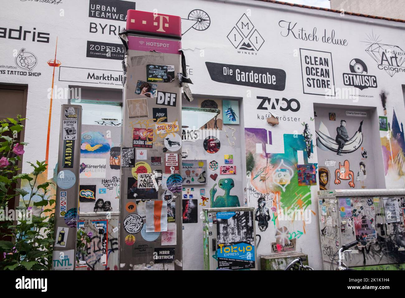 house wall and public phone with graffitis, paste-ups and logos of the shops located here, Koerner street in Ehrenfeld district, Cologne, German Hausw Stock Photo