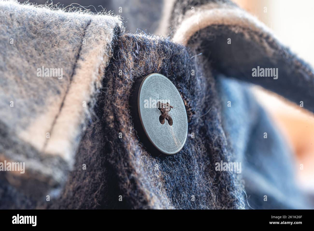 Button on a warm blue shirt, macro shot. Stock Photo