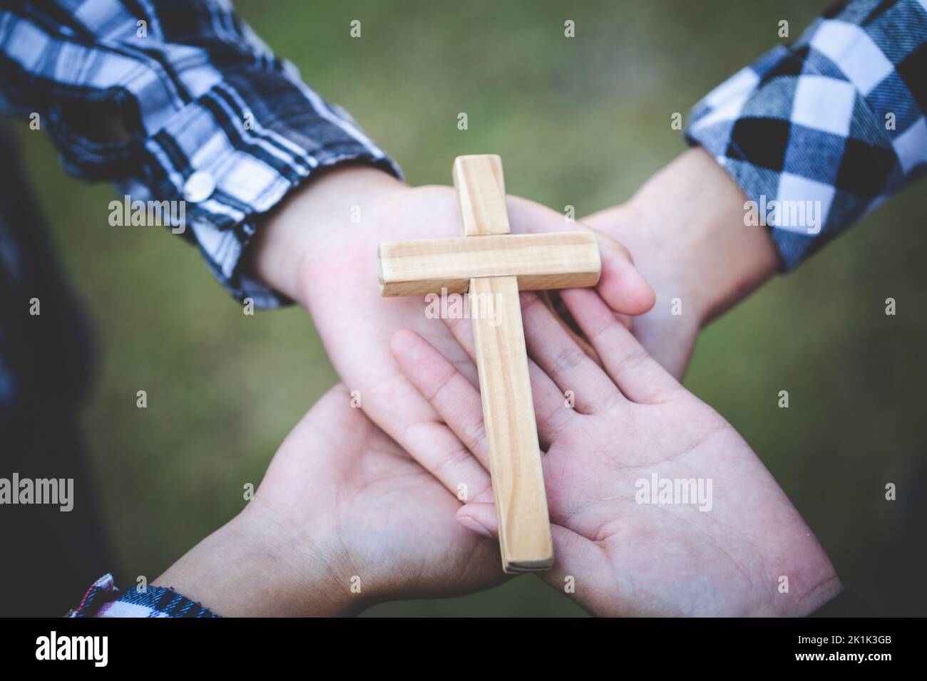 Religious concepts, The hands of a group of teenagers holding a cross. Eucharist Therapy Bless God Helping Repent Catholic Easter Lent Mind Pray. Chri Stock Photo