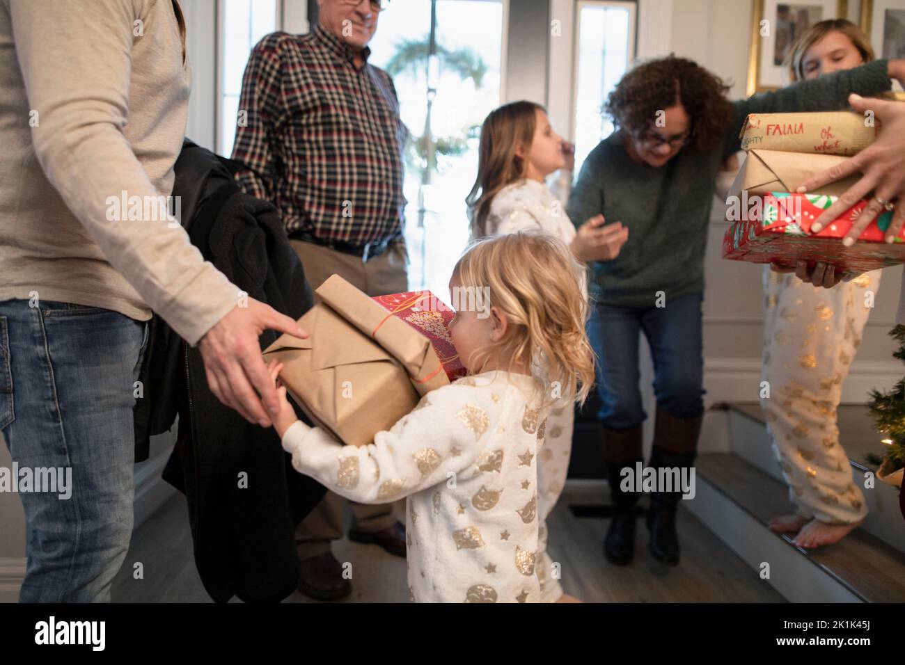 Grandchildren greeting grandparents arriving for Christmas with gifts