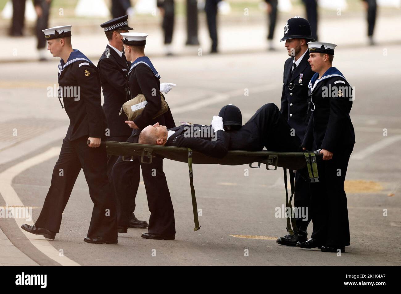 A police officer is stretchered away after collapsing on the day of state funeral and burial of Britain's Queen Elizabeth, in London, Britain, September 19, 2022 REUTERS/John Sibley Stock Photo