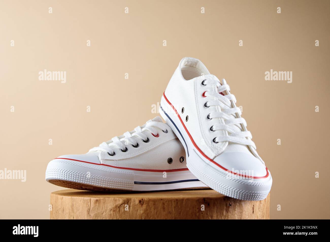 Pair of trendy shoes on beige background. Sport sneakers with copy space, Summer footwear concept Stock Photo