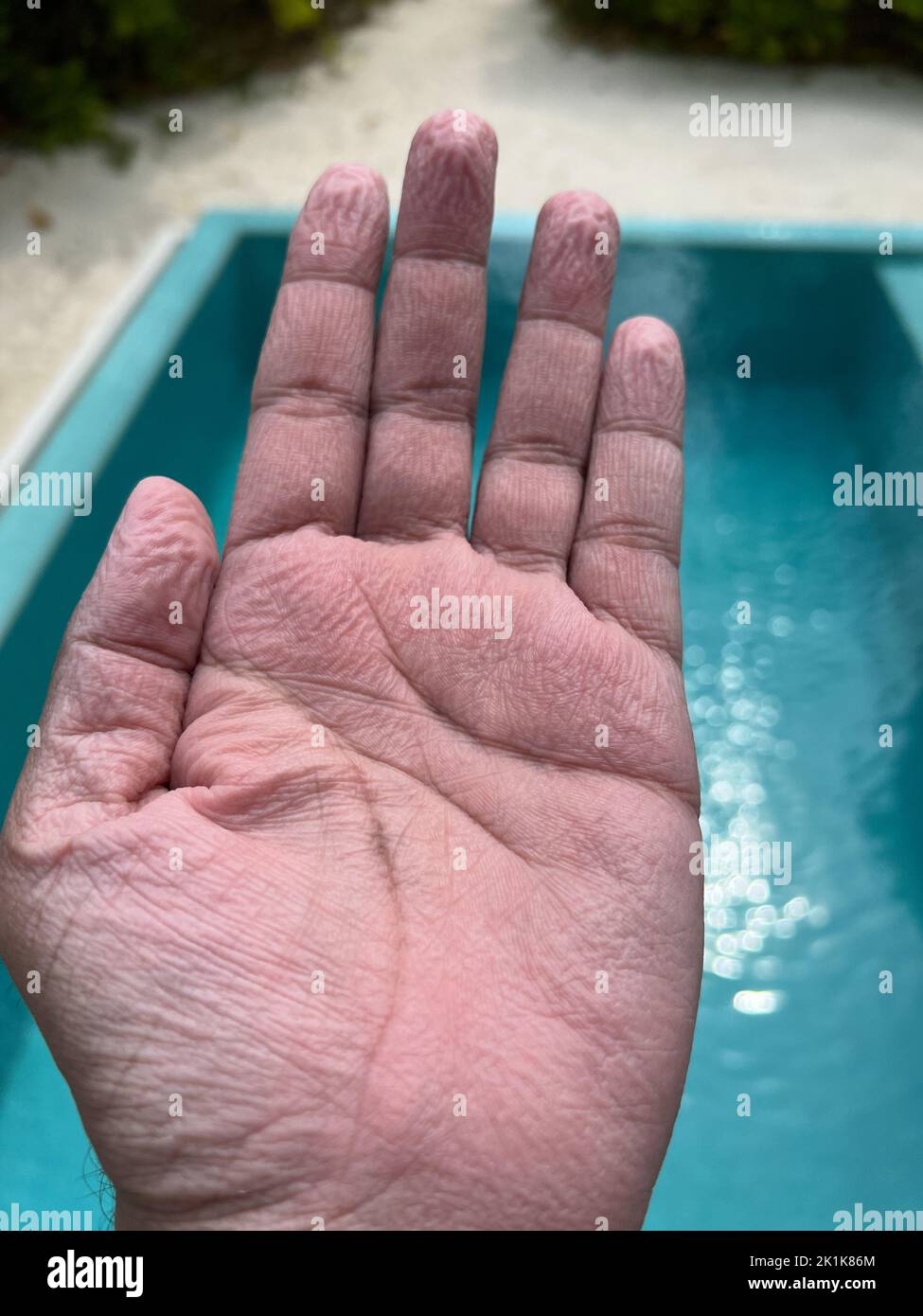 Wrinkly palm and fingers of an adult human after spending a lot of time