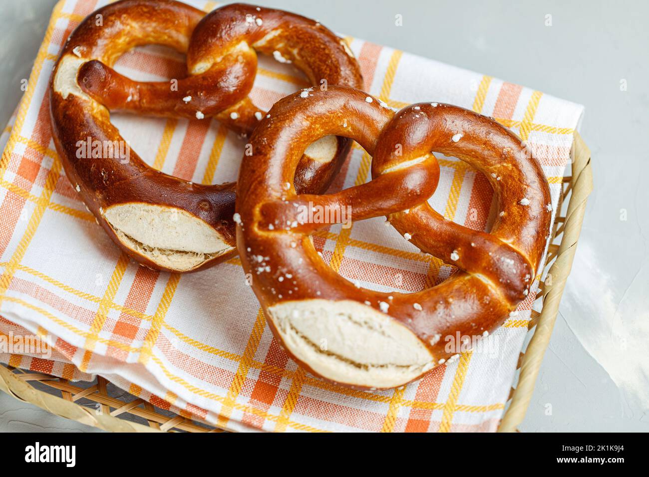 Two homemade freshly baked soft pretzels in bread basket with napkin
