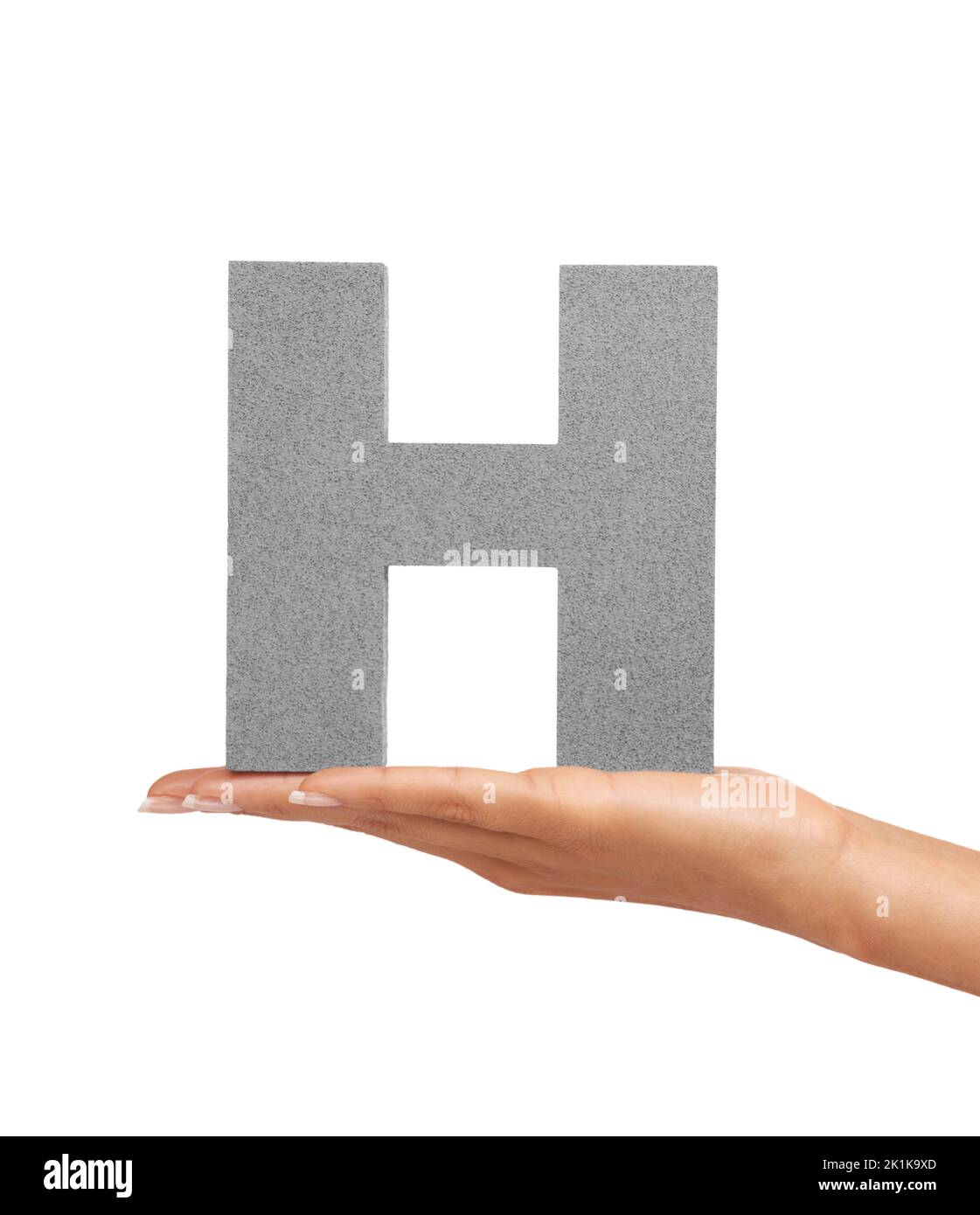 How do you do. A young woman holding a capital letter H isolated on a white background. Stock Photo