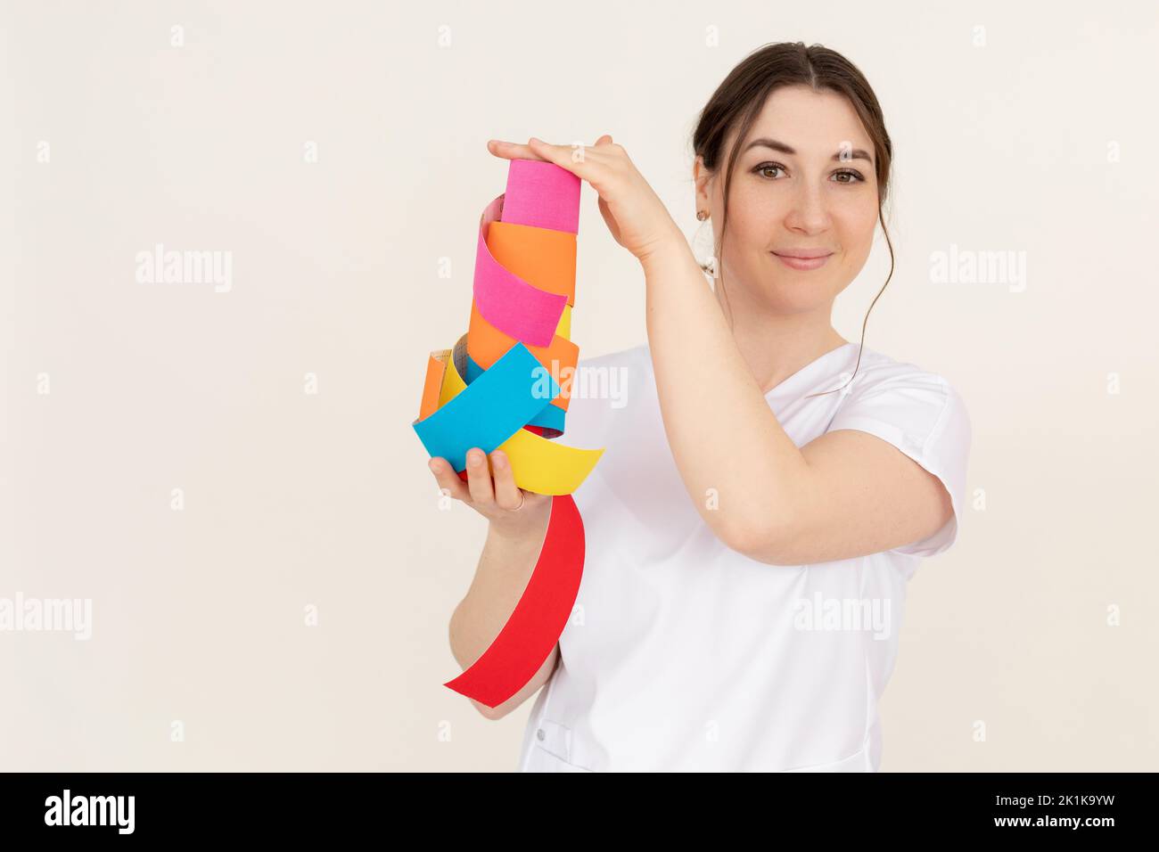 Portrait of young smiling pretty masseuse woman wearing white uniform