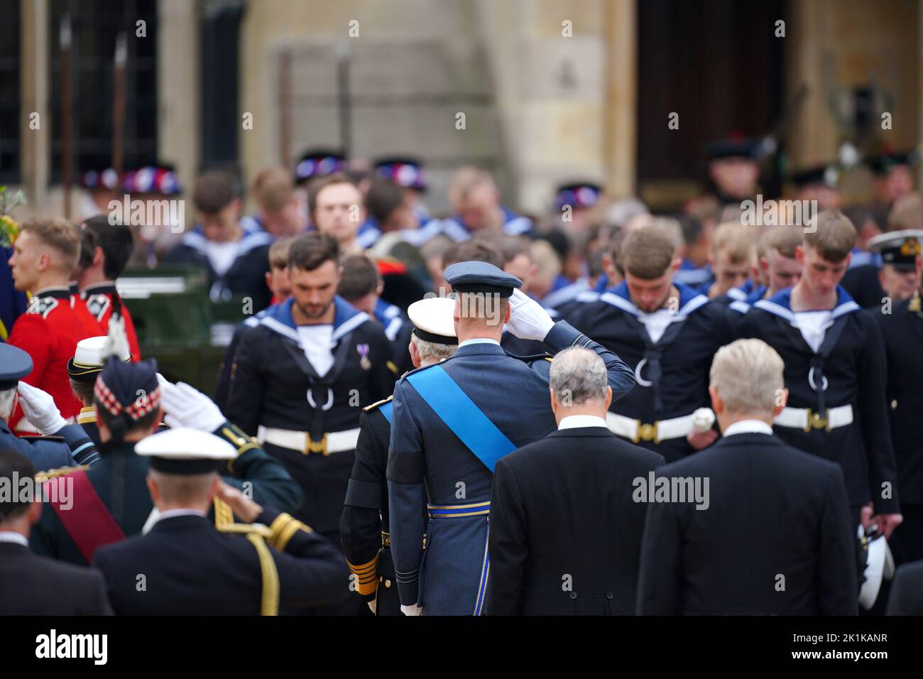 The Prince of Wales (centre) salutes the coffin of Queen Elizabeth II, draped in the Royal Standard with the Imperial State Crown and the Sovereign's orb and sceptre, in the Ceremonial Procession during her State Funeral at Westminster Abbey, London. Picture date: Monday September 19, 2022. Stock Photo