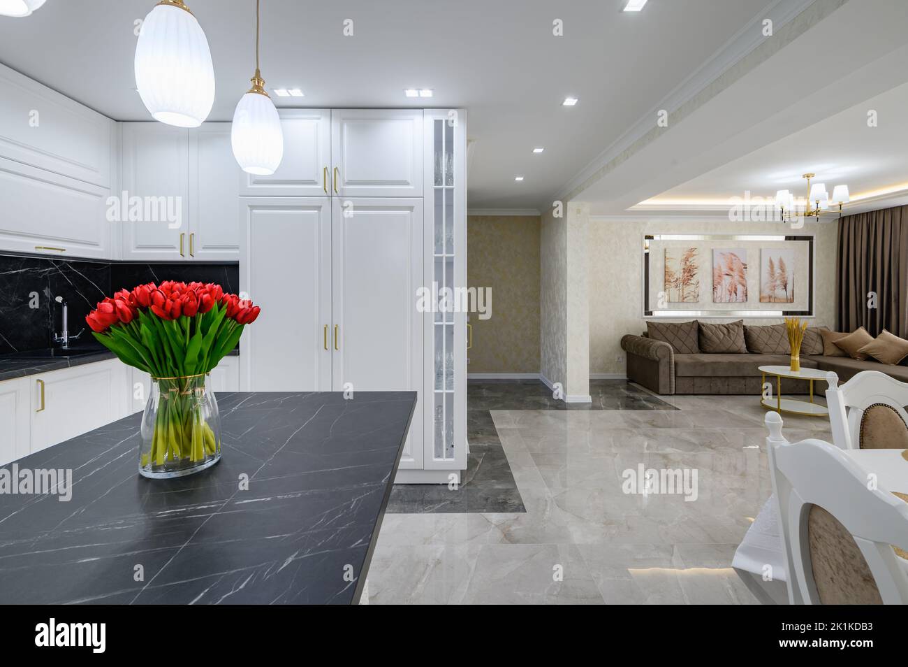 Luxurious white modern domestic kitchen with black marble worktop Stock Photo