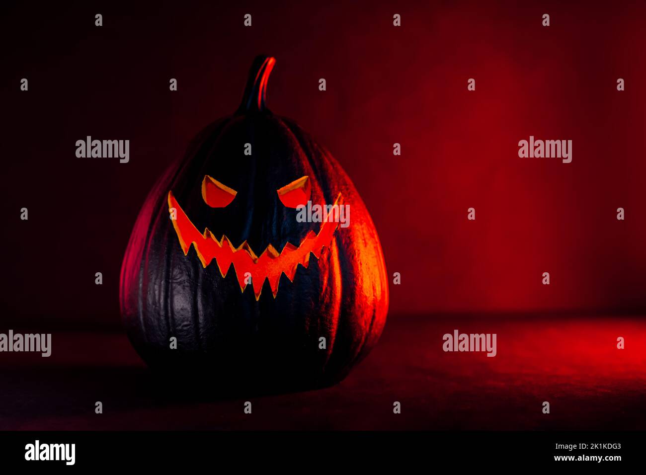 Spooky halloween black pumpkin, Jack O Lantern, with illuminated evil