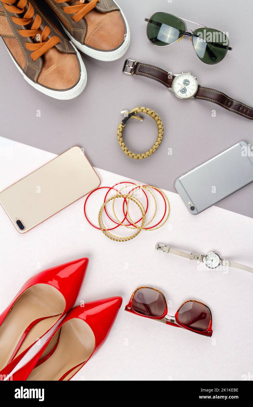 Flat lay composition of womens and mens accessories. Vertical shot top view contrast of male and female belongings. Stock Photo