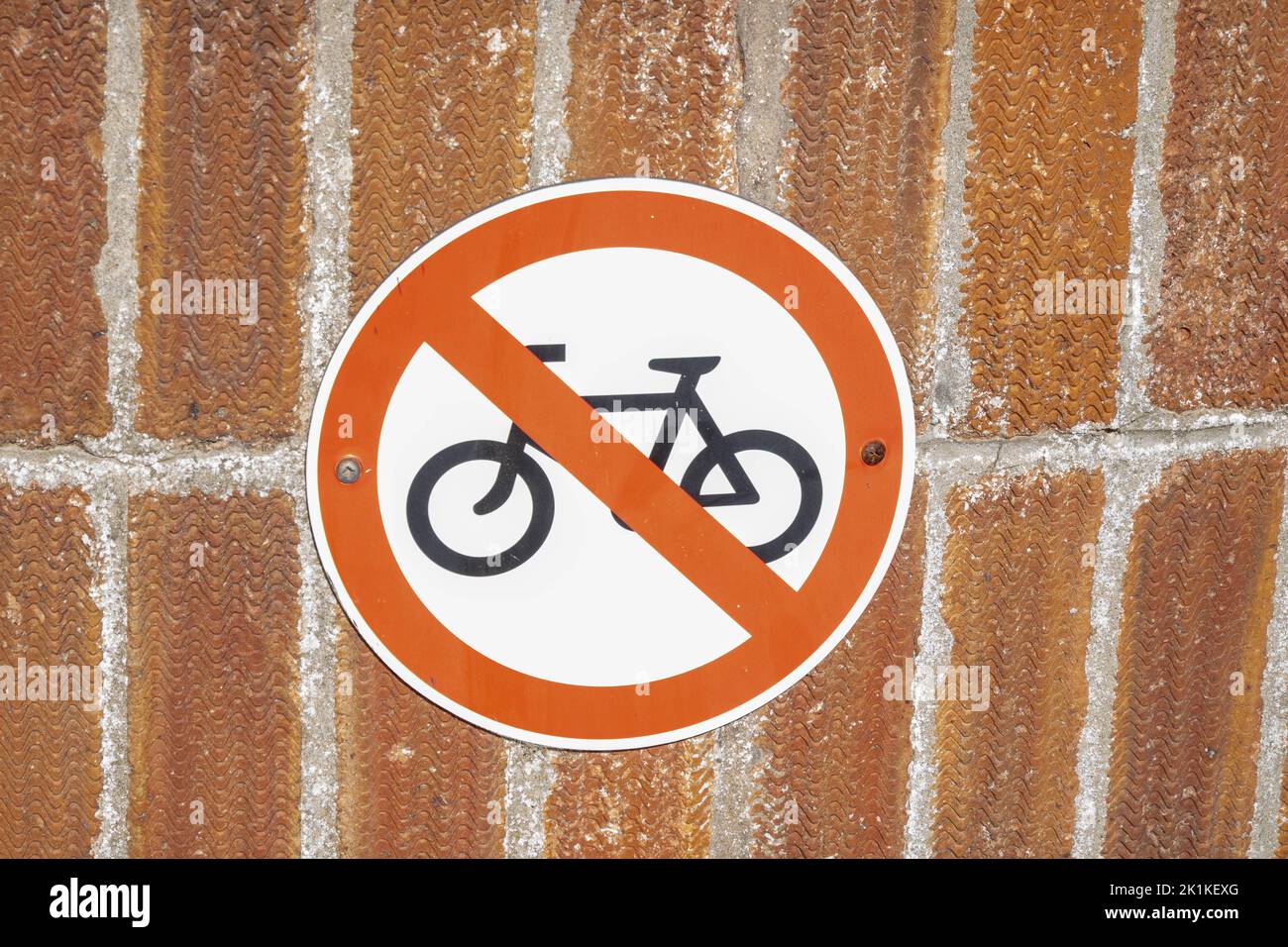 A round NO CYCLING sign on a brick wall Stock Photo