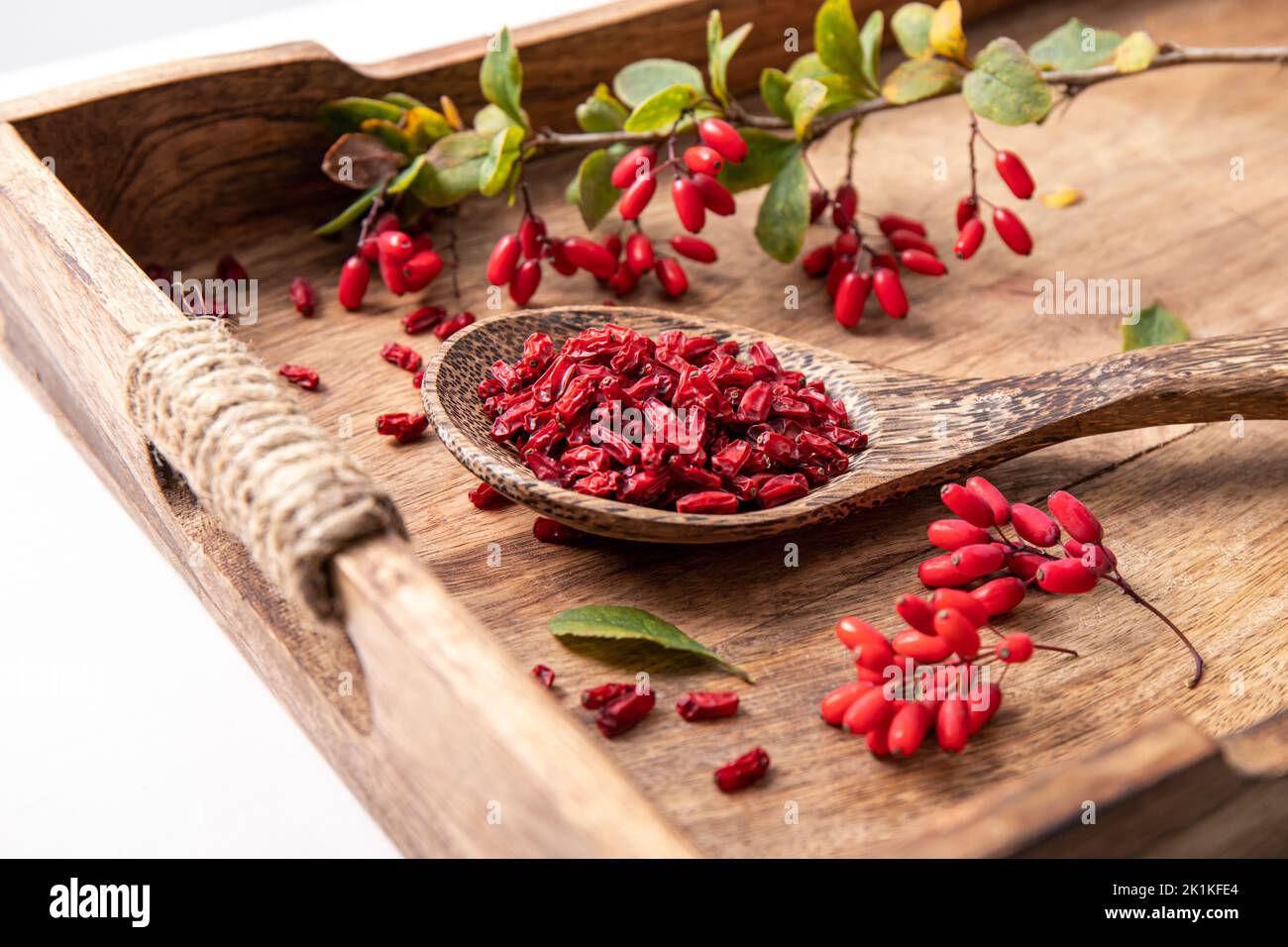 Pile of dried Berberis vulgaris also known as common barberry, European barberry or barberry on plate in home kicthen. Edible herbal medicinal red fru Stock Photo