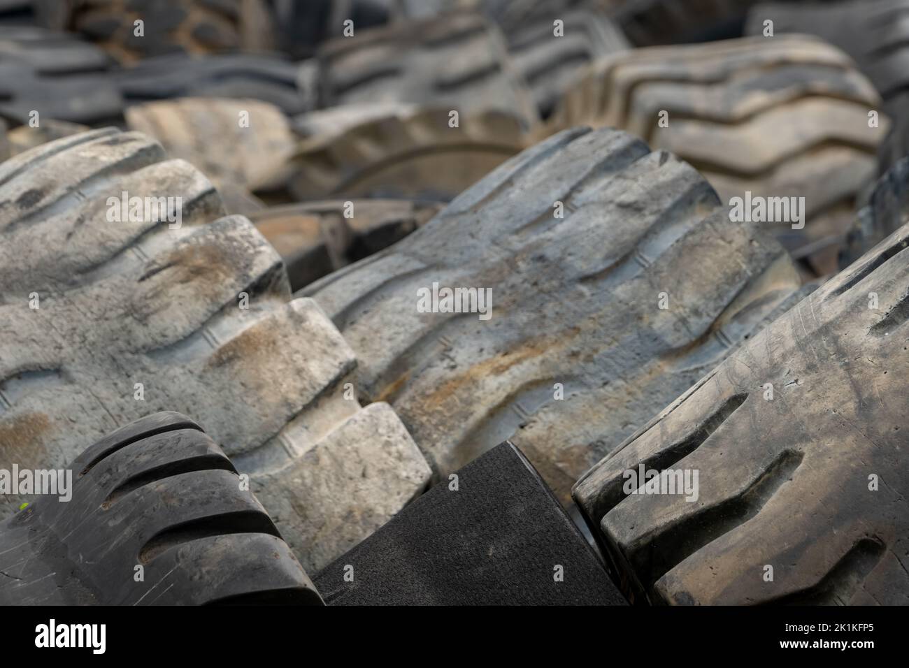 Closeup used truck tires. Old tyres waste for recycle or for landfill. Black rubber tire of truck. Pile of used tires at recycling yard. Material Stock Photo