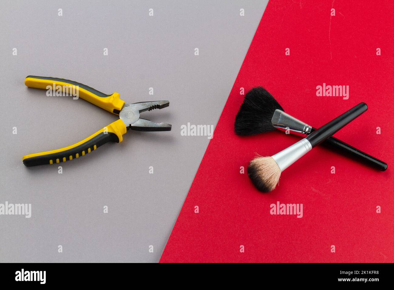 Top view pliers and two makeup brushes. Man versus woman concept. Stock Photo