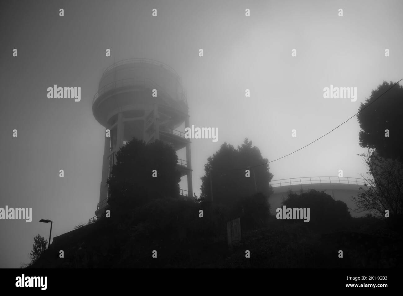 View of the water tower early in the morning in thick fog. Black and white photo. Stock Photo