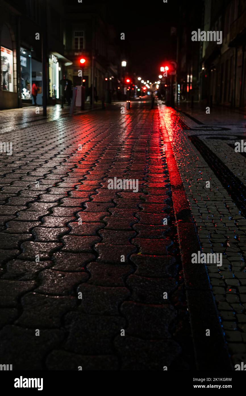 A wet sidewalk at night in the lights in the center of the old city of Porto, Portugal. Stock Photo