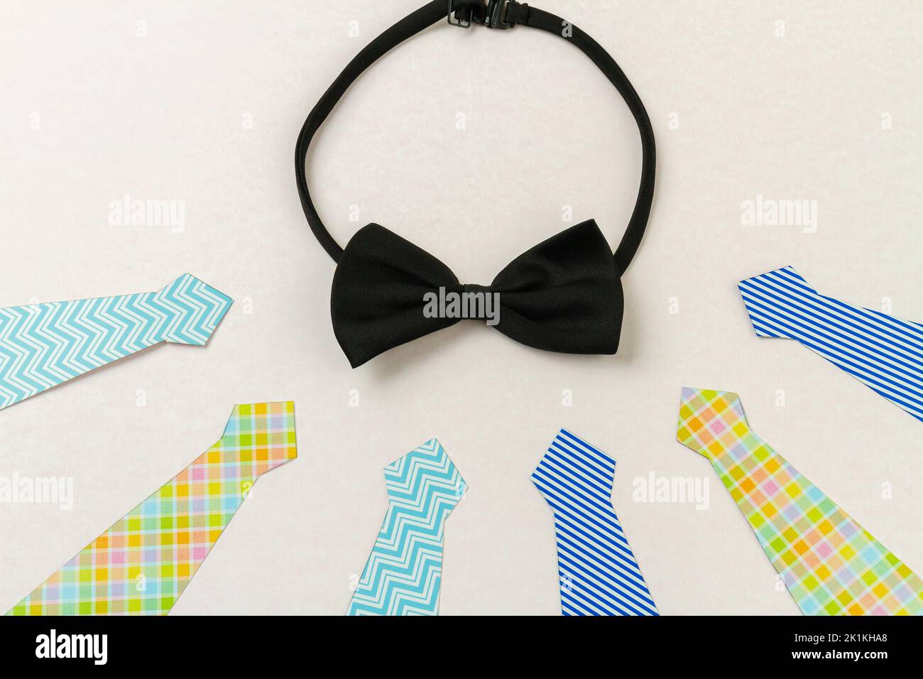 Black bow tie and neckties on white surface. Fathers day concept. Stock Photo