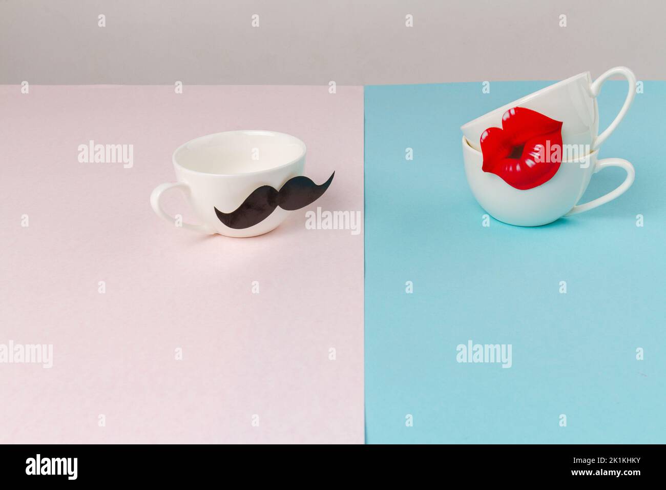 White ceramic cups decorated with moustache and lips. Cute romantic card for valentines day. Stock Photo