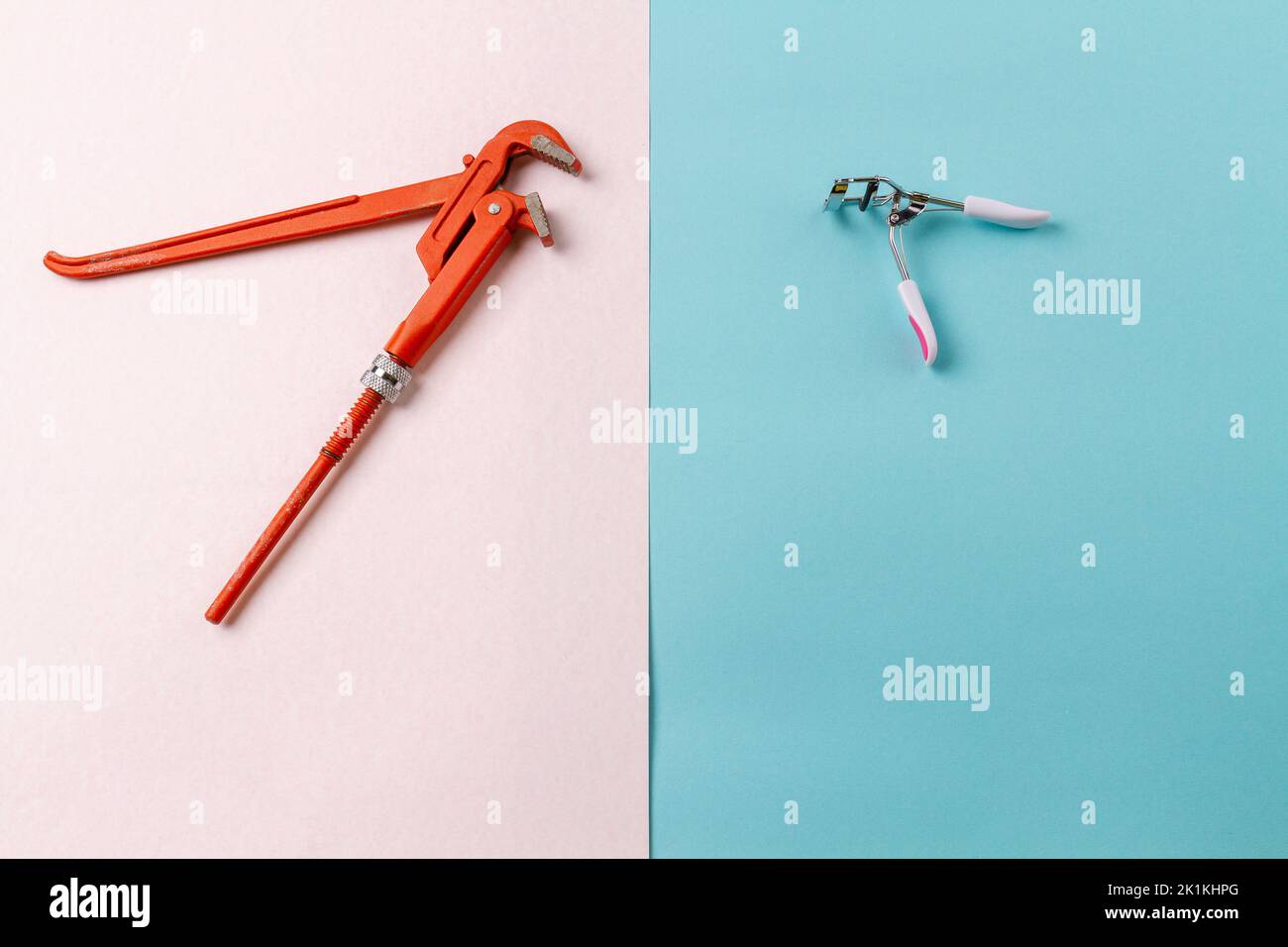 Top view adjustable wrench and eyelash curler. Contrast of mens and womens accessories. White and turquoise surface. Stock Photo