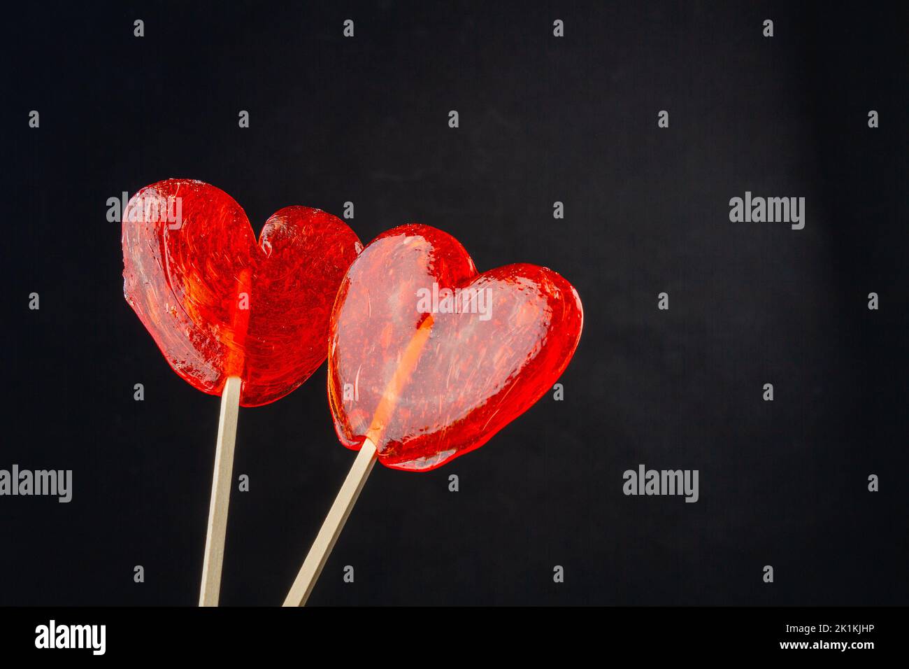 Two red lollipop candies and copy space. Isolated on black. Stock Photo