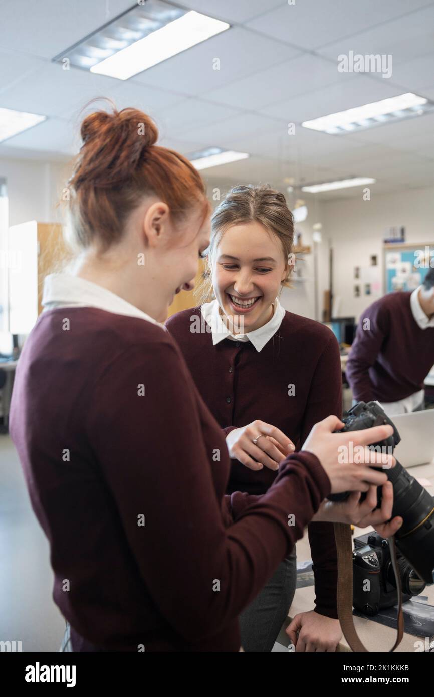 High school girl students using digital camera in classroom Stock Photo