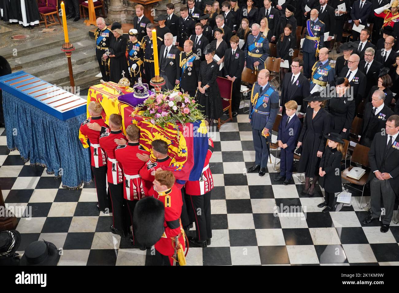The coffin of Queen Elizabeth II, draped in the Royal Standard with the Imperial State Crown and the Sovereign's Orb and Sceptre, is carried by the Bearer Party the royal family look on (front row) King Charles III, the Queen Consort, the Princess Royal, Vice Admiral Sir Tim Laurence, the Duke of York, the Earl of Wessex, the Countess of Wessex, the Prince of Wales, Prince George, the Princess of Wales, Princess Charlotte, Peter Phillips, (second row) the Duke of Sussex, the Duchess of Sussex, Princess Beatrice, Edoardo Mapelli Mozzi and Lady Louise Windsor, James, Viscount Severn, Jack Brooks Stock Photo