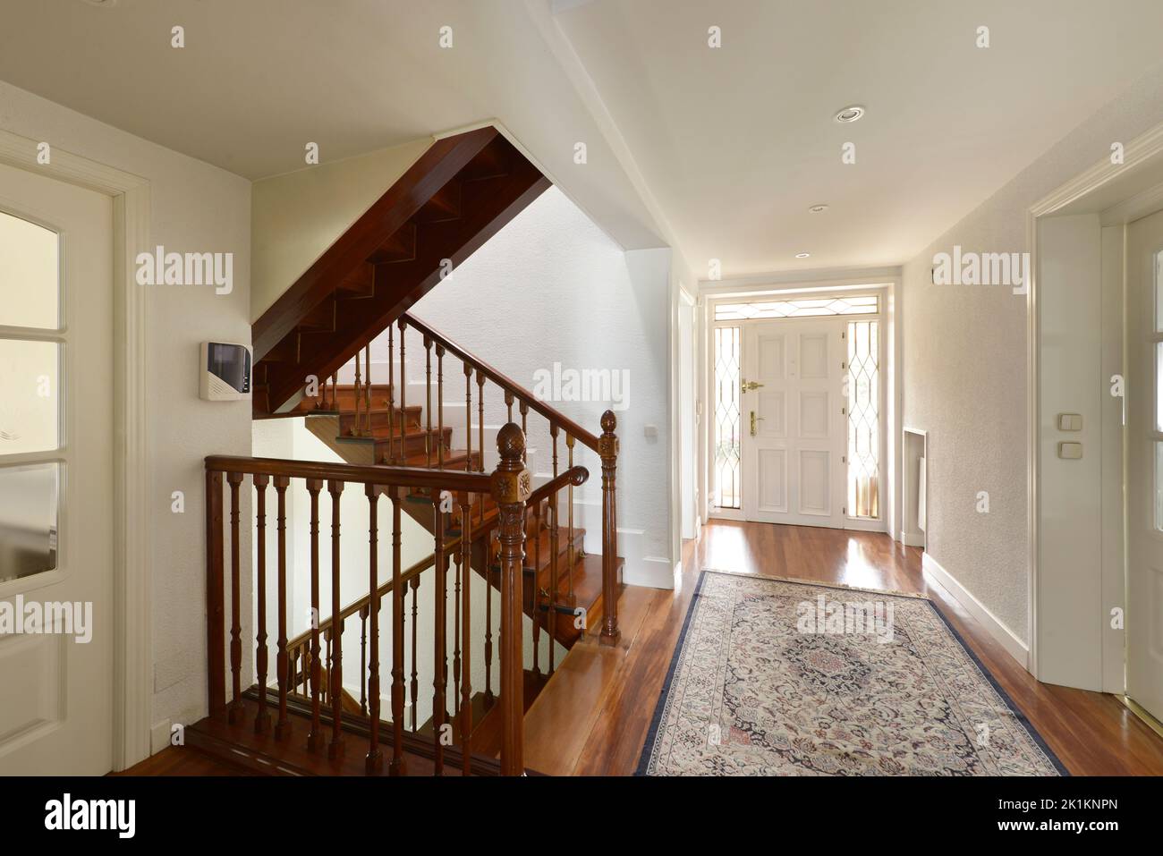 Hall of a single-family home entrance door with distribution wooden stairs to the different levels Stock Photo