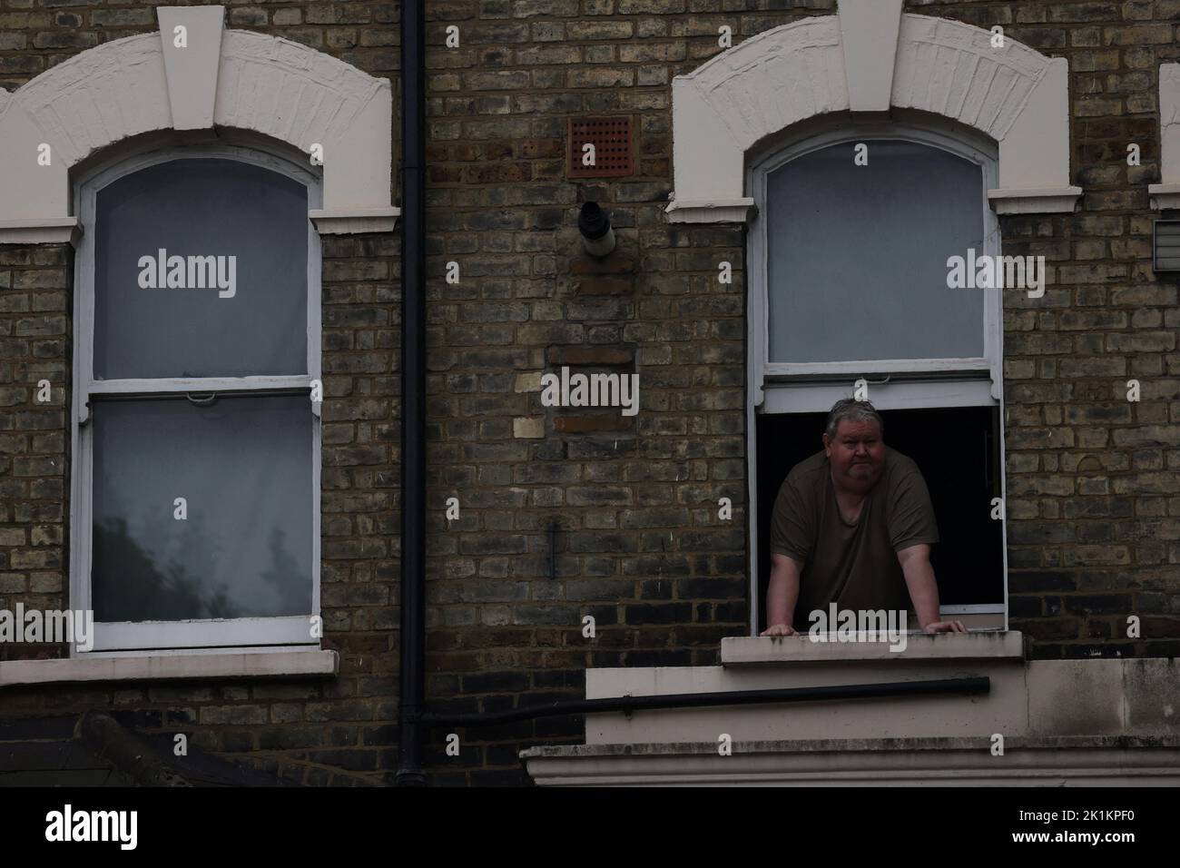 A man looks on from a window on the day of the state funeral and burial of Britain's Queen Elizabeth, in London, Britain, September 19, 2022. REUTERS/Carlos Barria Stock Photo