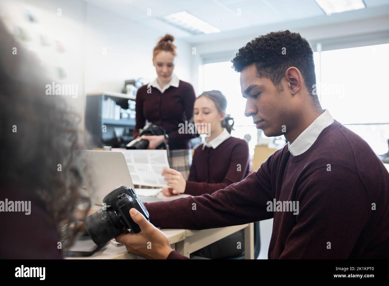 High school boy student with digital camera in yearbook classroom Stock
